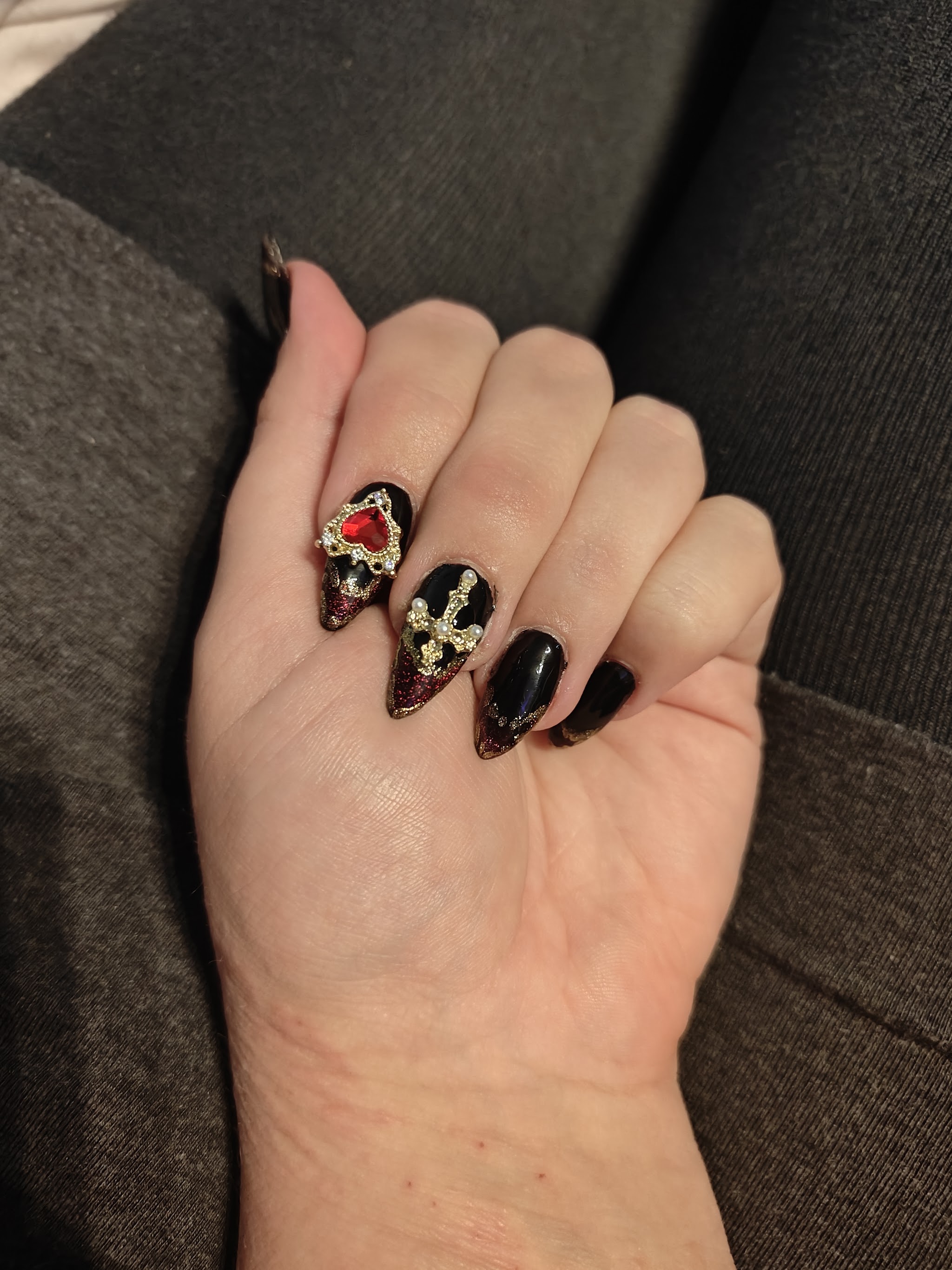 Zwarte nagels met sieraden en een rood hartje