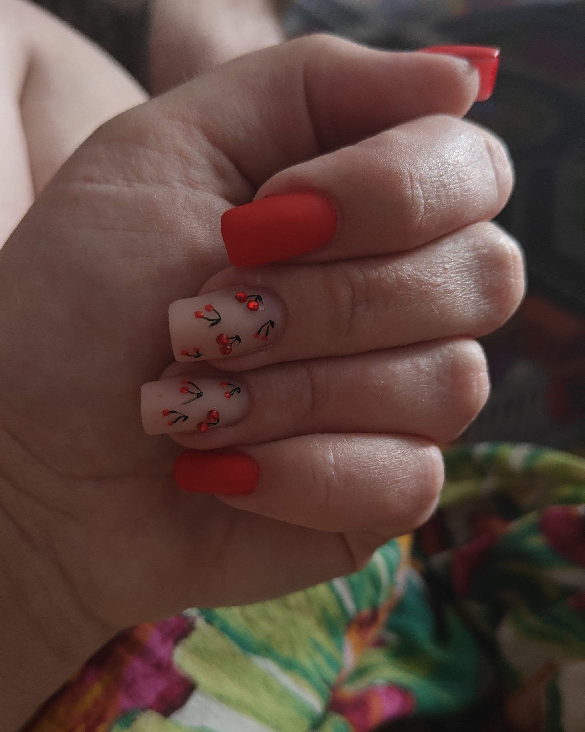 Rode nagels en handgeschilderde kersjes op nude